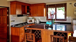 A kitchen with wooden cabinets, a central island, and a window with a view of greenery.