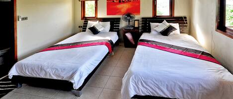 A hotel room with two beds, a red abstract painting, and a window with a view.
