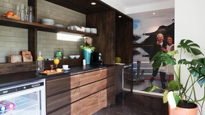 A modern kitchen with wooden cabinetry, a built-in refrigerator, and a large window overlooking a scenic landscape.