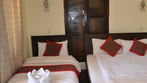 Two adjacent hotel rooms with wooden headboards, white bedding, and red decorative pillows. - Hotel Peace N Park (Kathmandu)