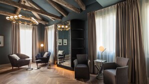 Una sala de estar moderna con vigas de madera, un espejo grande y un suelo de madera en espiga.