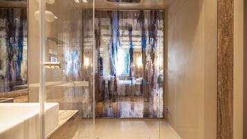 A modern bathroom with a glass partition, a white sink, and a marble countertop.