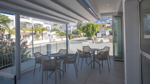 A balcony with outdoor seating, a view of the city, and a modern building facade. - Pavlinia Hotel Apartments (Ayia Napa)