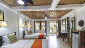 Una habitación de hotel con dos camas, un escritorio, un refrigerador y un comedor.