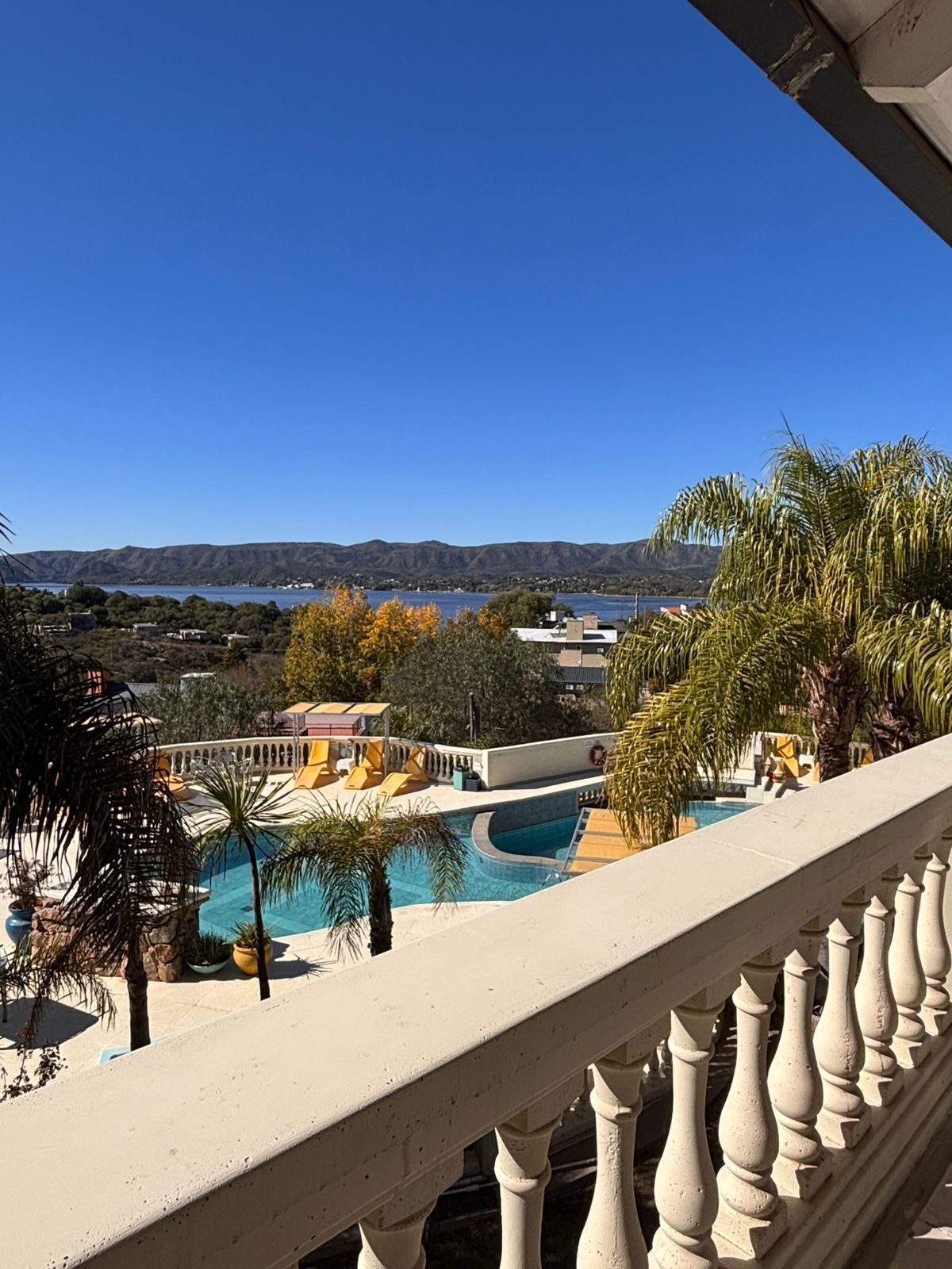 Zona de piscina con vistas a montañas y cielo despejado.