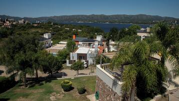 A residential area with houses, a clear blue sky, and a body of water in the background.