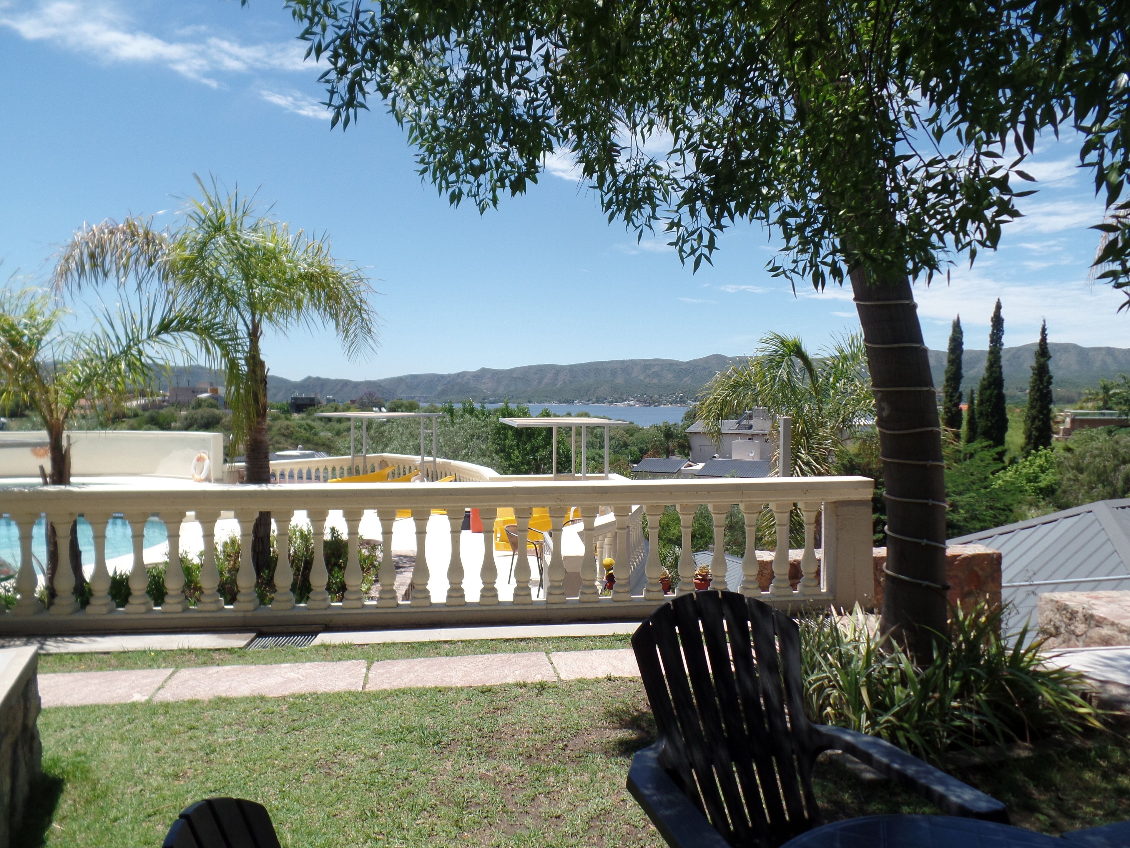 Un patio con piscina, una silla y vistas al paisaje.