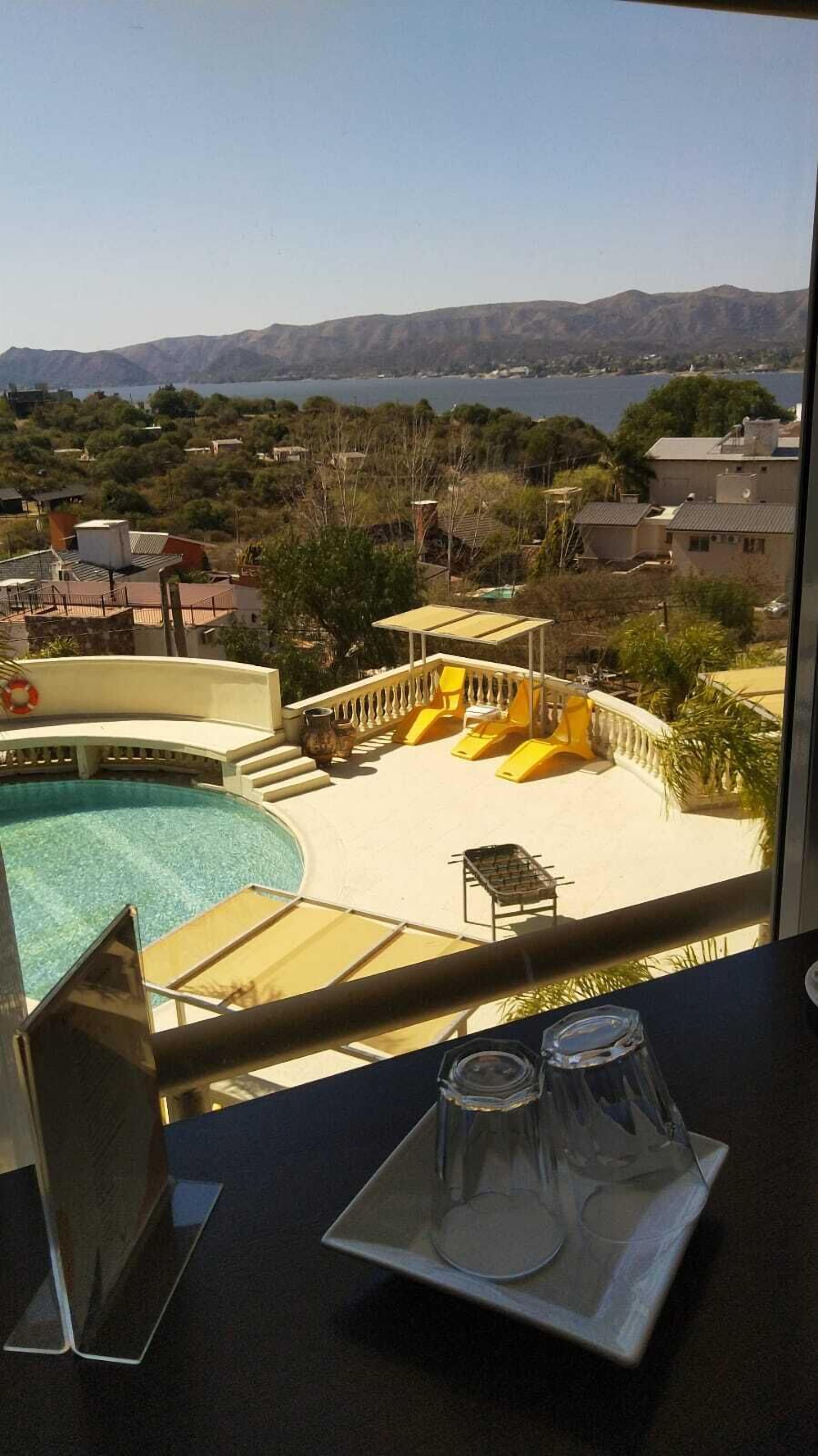 Un área de piscina con vistas a montañas y un lago.