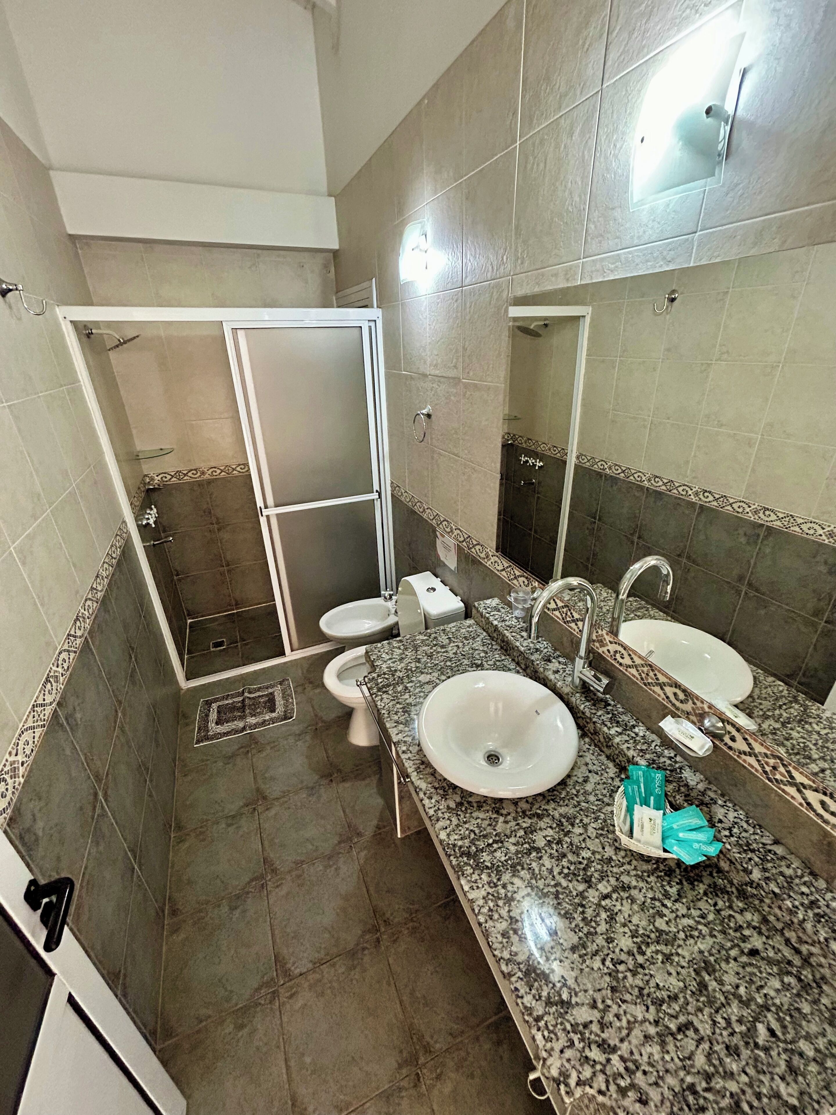 Une salle de bain avec deux lavabos, une douche et des toilettes.
