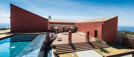 Piscine extérieure, piscine à débordement, chaises longues