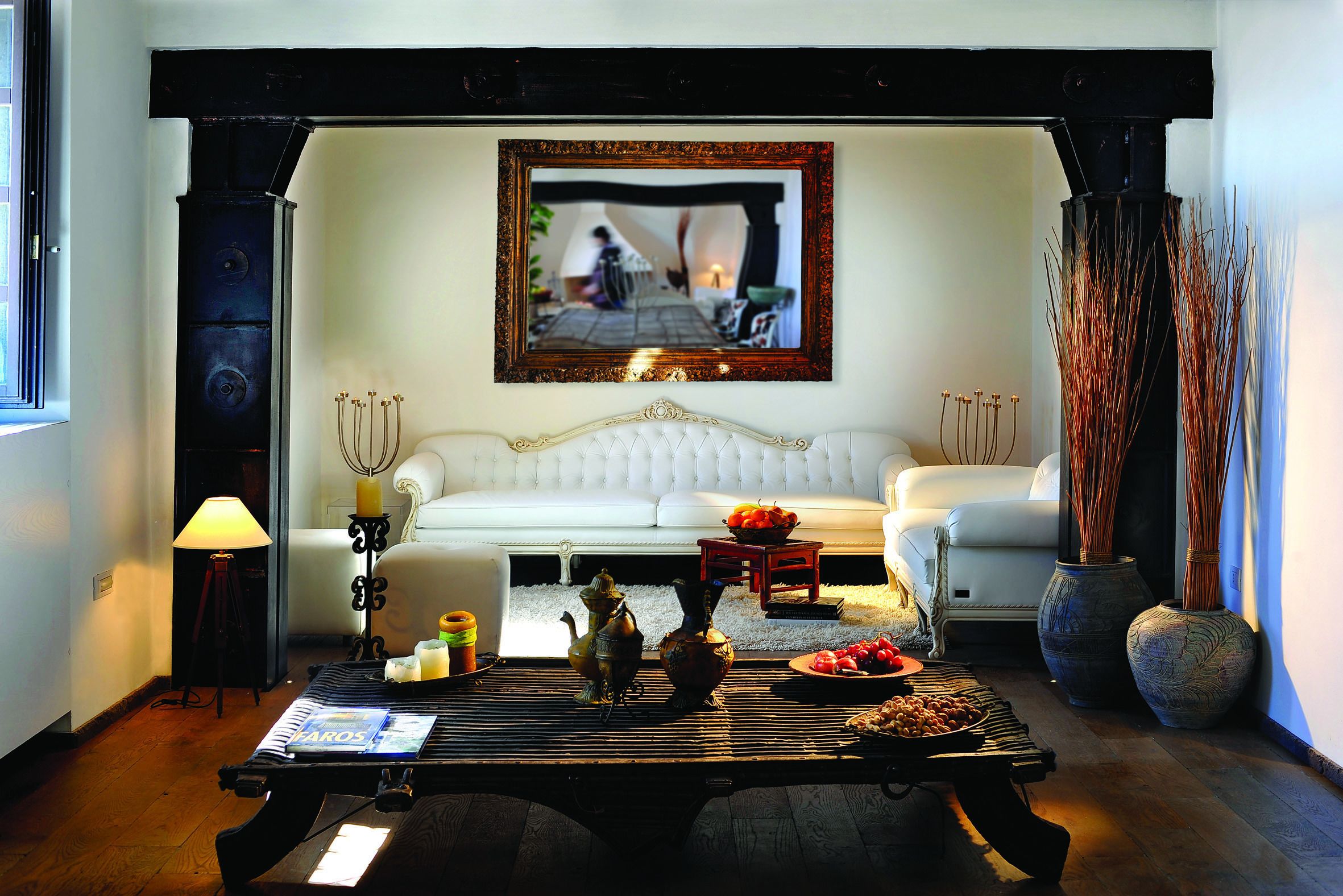 A cozy living room with a white sofa, a coffee table with decorative items, and a framed picture on the wall.