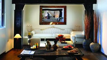 A cozy living room with a white sofa, a coffee table with decorative items, and a framed picture on the wall.