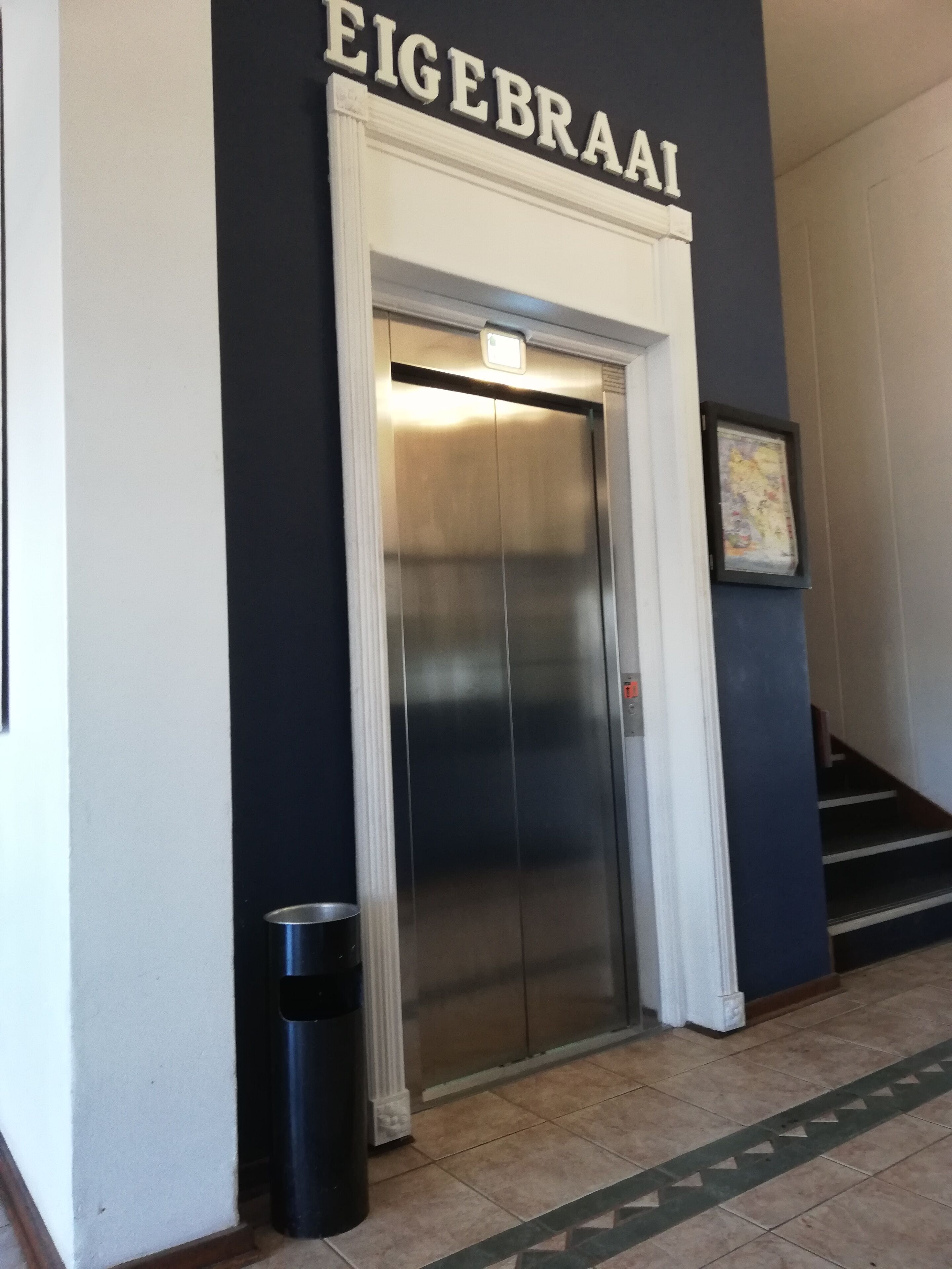 Een lift met een bord erboven met de tekst 'EIGEBRAAI'.