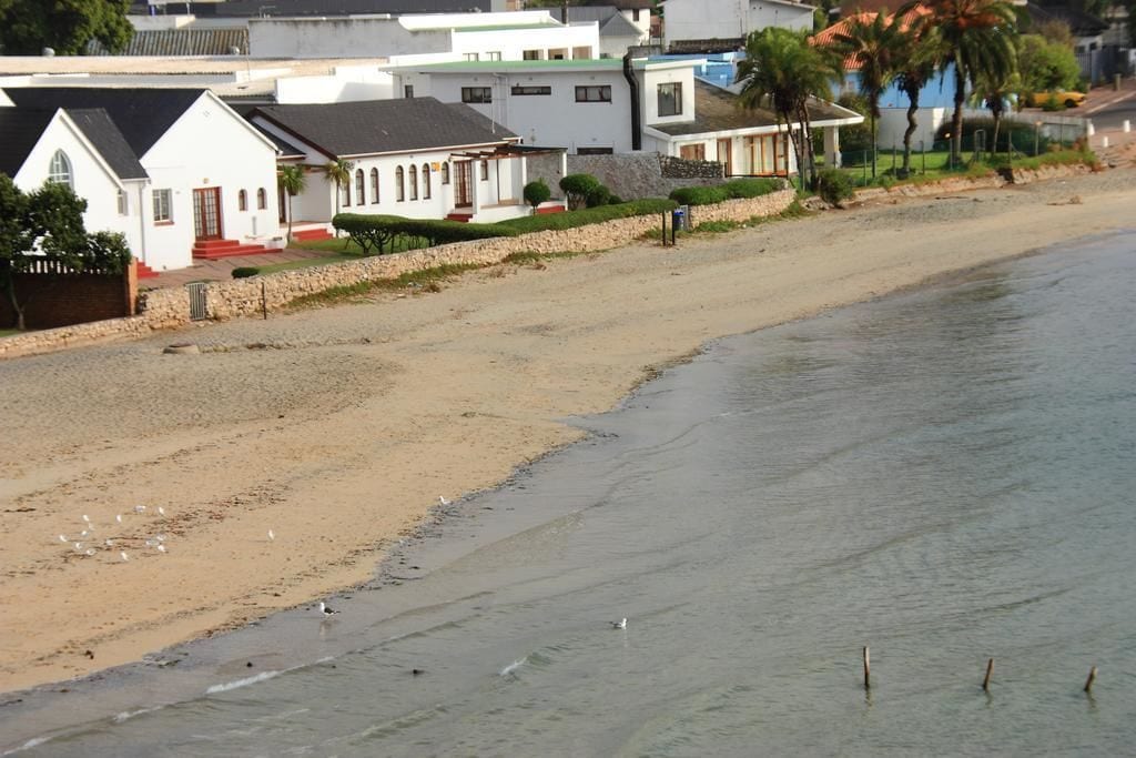 Una playa con edificios blancos y una vista despejada del océano.