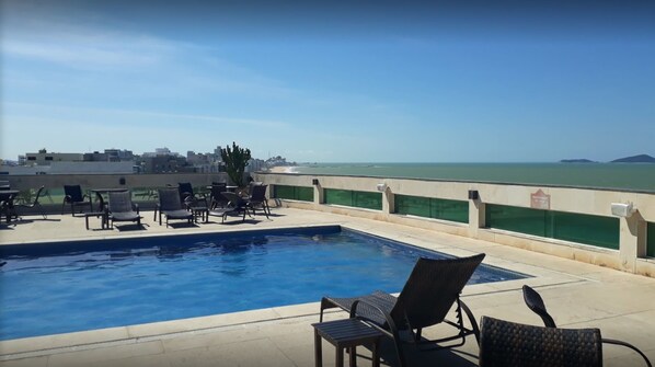 A rooftop pool with lounge chairs and a view of the ocean. - Royal Macaé Palace Hotel (Macaé)