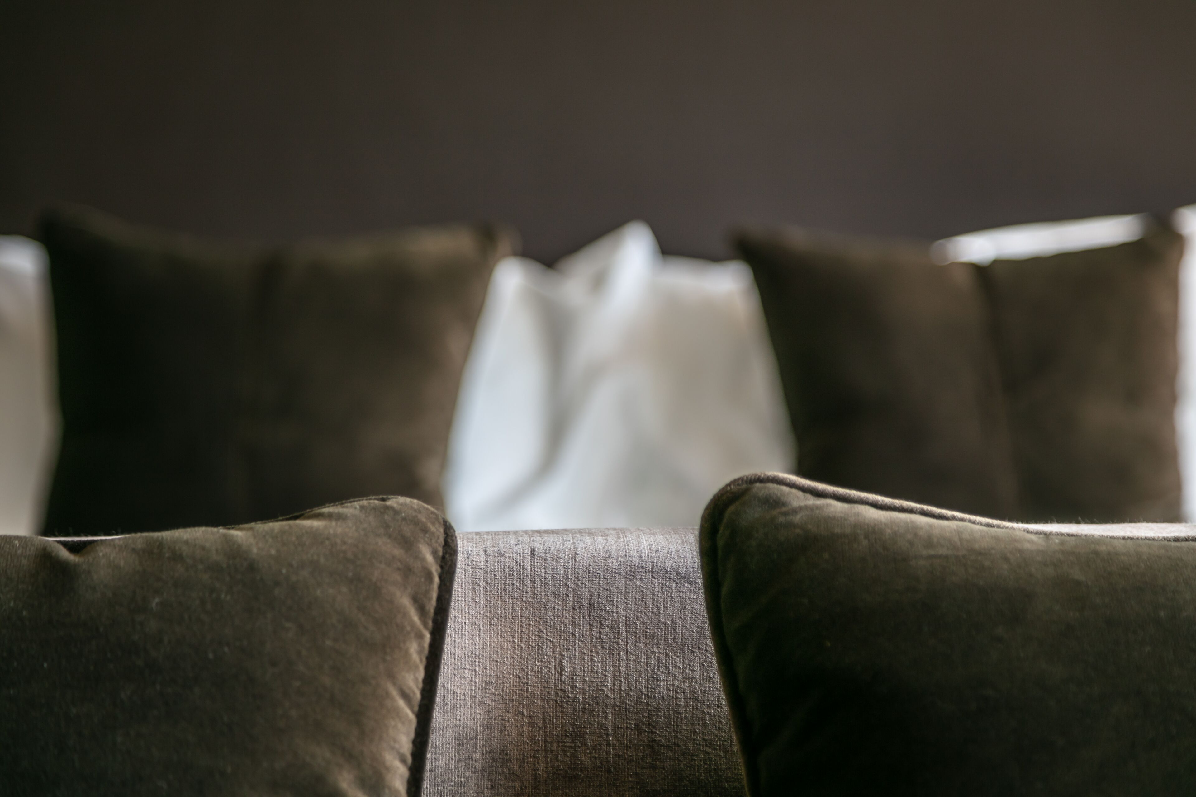 Ein Detailaufnahme eines Sofas mit vielen Kissen.