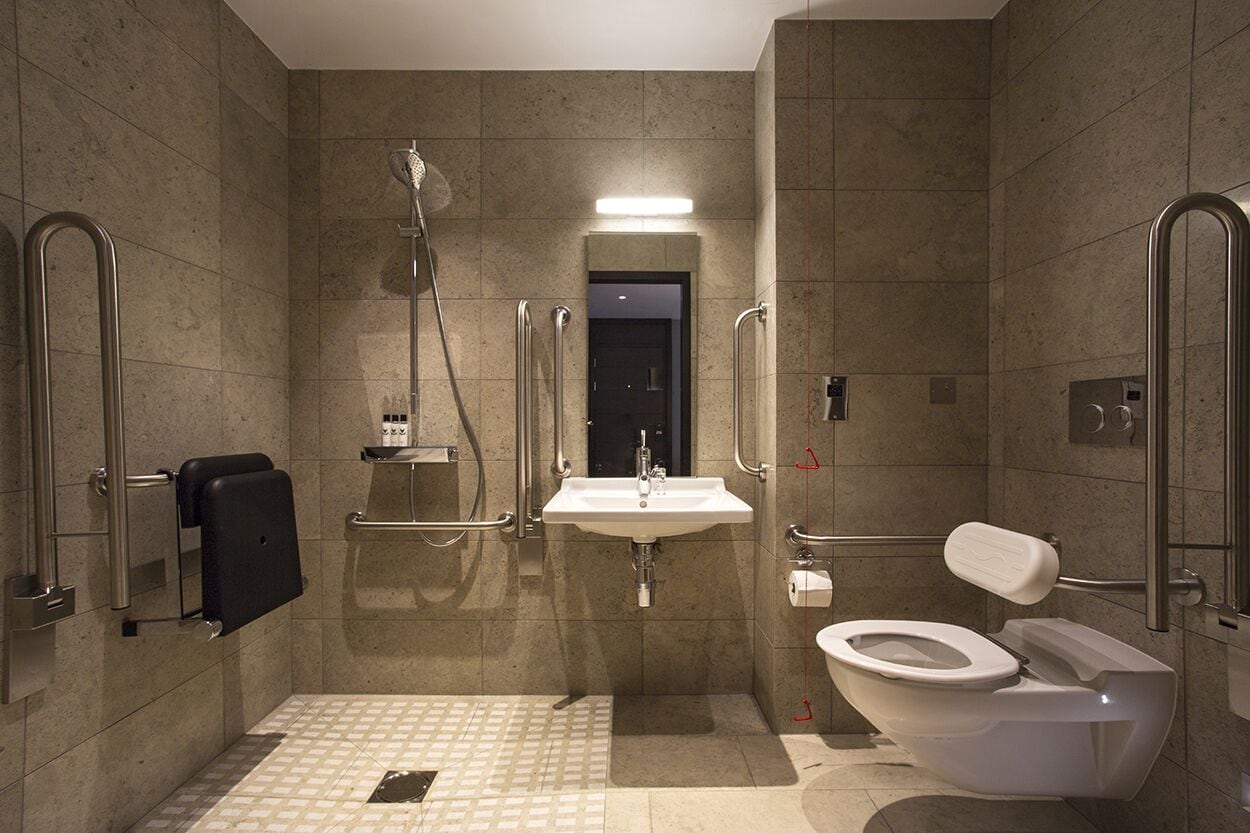 A modern bathroom with a shower, sink, and toilet.