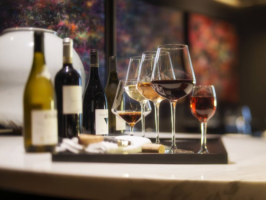 Una degustación de vinos con varias botellas y copas sobre una encimera de mármol.
