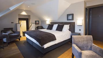A modern bedroom with a large bed, a chair, and a desk.