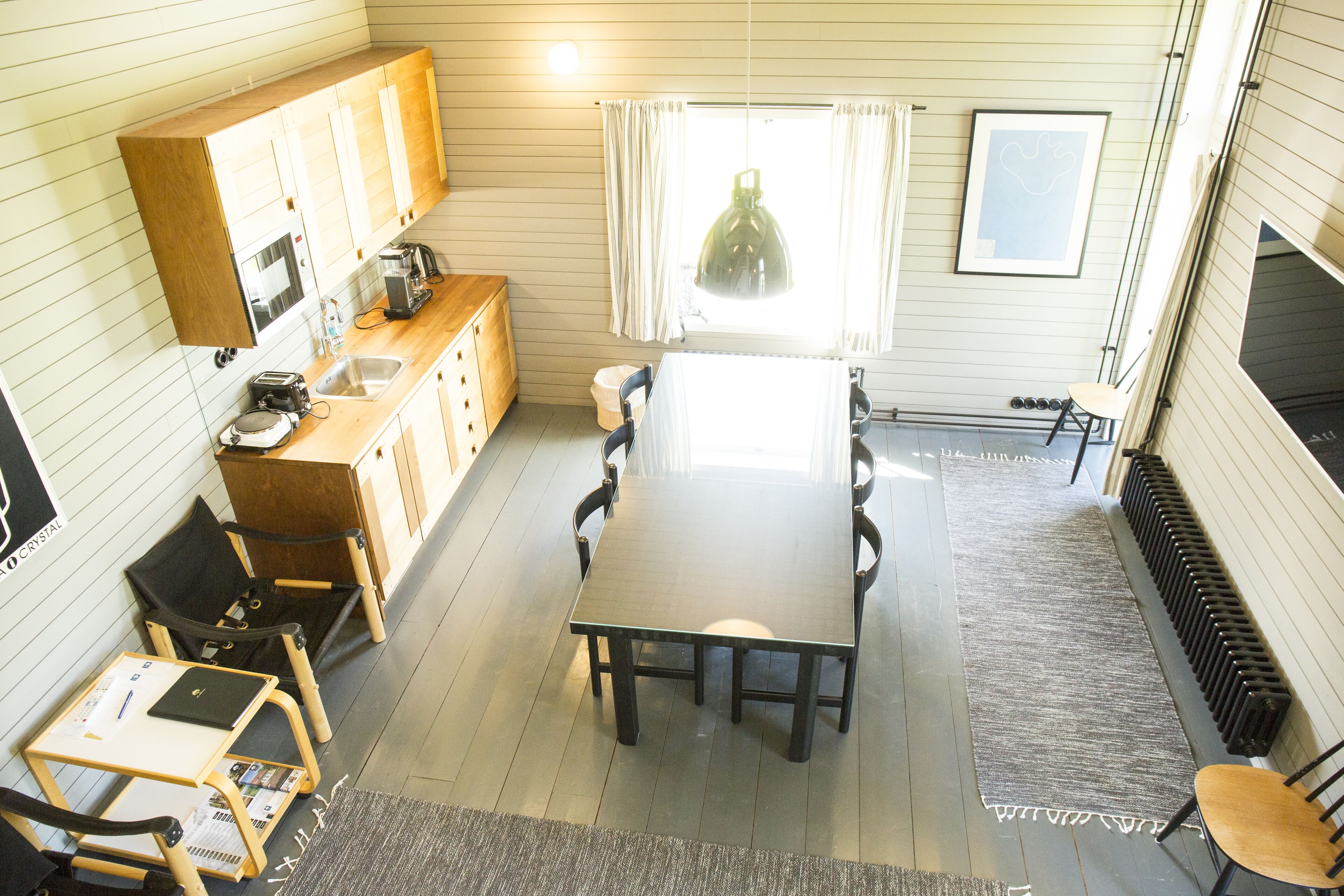 A compact kitchen with wooden cabinets, a dining table, and chairs.