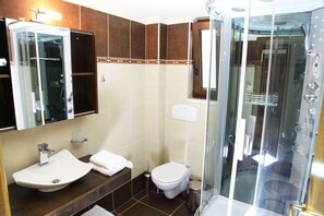 A bathroom with a glass-enclosed shower, a sink, and a toilet. - Villa Veghera (Kissamos)
