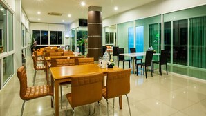 Un vaste espace dédié à la salle à manger, avec de nombreuses tables et chaises, de grandes fenêtres et un aménagement intérieur moderne.