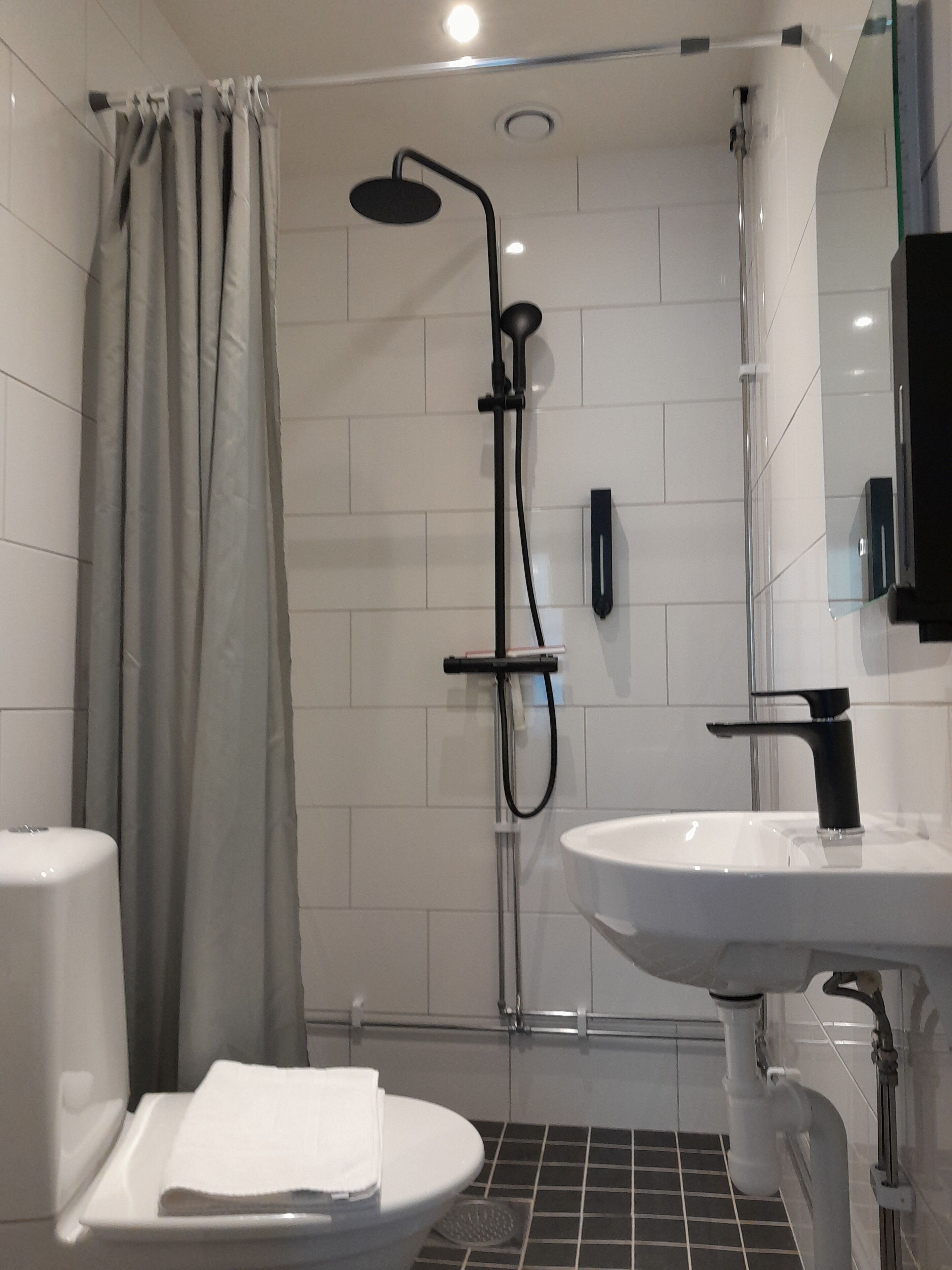 deluxe single room | bathroom | shower, hair dryer, towels, soap