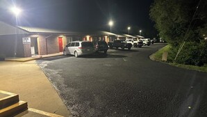 A parking lot with several cars parked in front of a building with a 'VENDING' sign.
