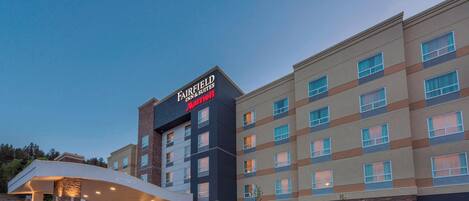 A Fairfield Inn & Suites hotel with a modern design, featuring a prominent entrance and a parking area with handicapped accessibility.