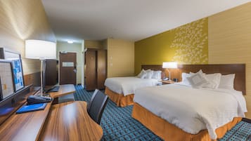 Une chambre d’hôtel avec deux lits, un bureau, une chaise, une télévision et une lampe.