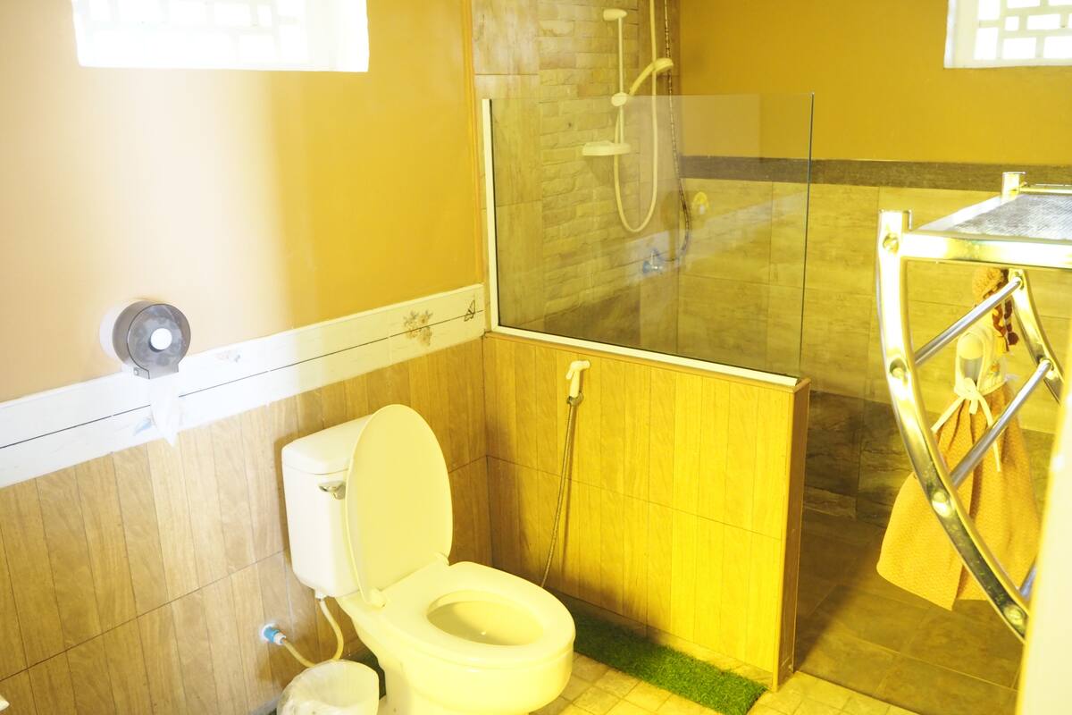 A bathroom with a toilet, a shower, and a sink.