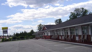Un motel con estacionamiento y un letrero.