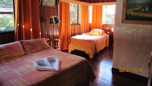 A cozy room with two beds, a painting, and a window with curtains. - Hotel Villa Verde (Monteverde)