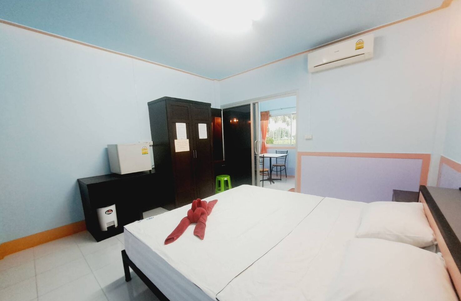 Een hotelkamer met een bed, een bureau, een kledingkast en een airconditioner.