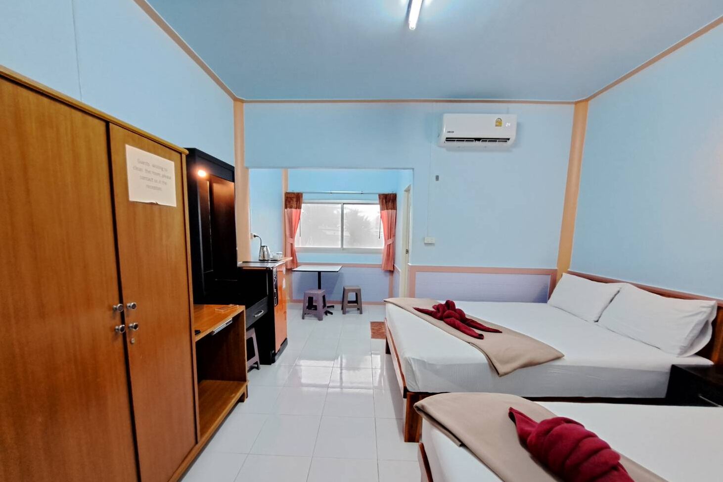 Una habitación de hotel con una cama, un escritorio, un armario y una ventana.