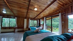 Una cabaña de madera con dos camas, un balcón y ventanas amplias.