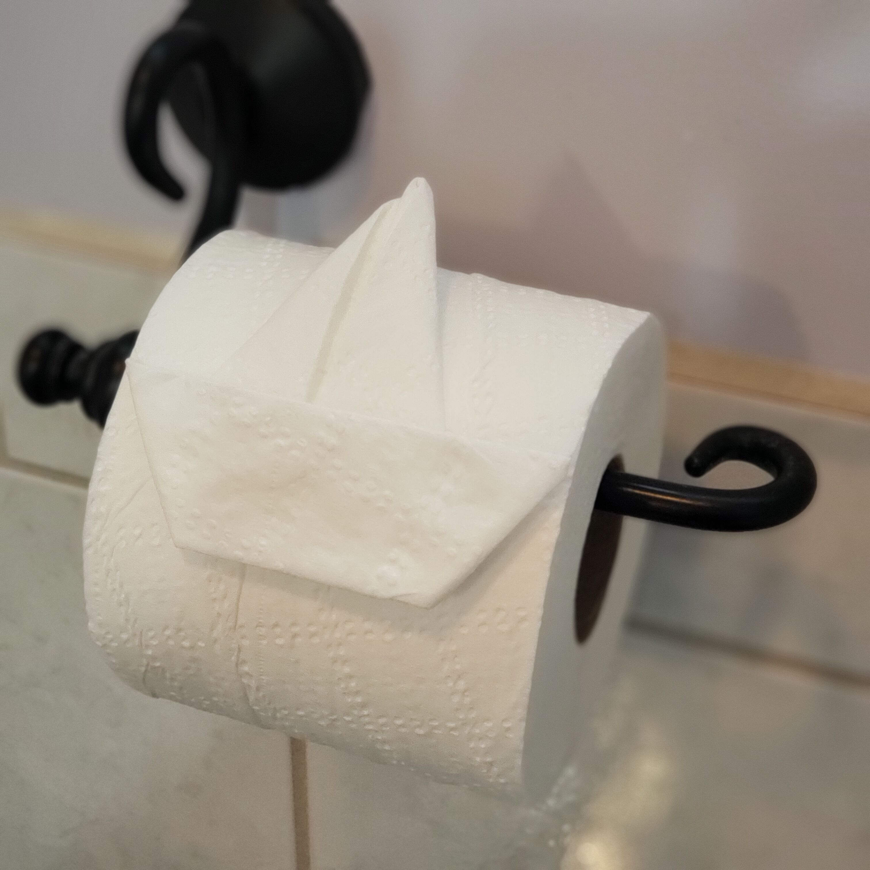 Un rollo de papel higiénico sujeto a un soporte negro.