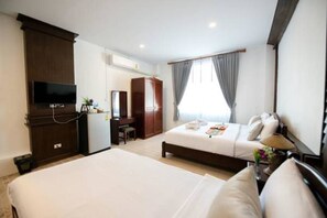 A hotel room with two beds, a desk, a TV, and a wardrobe. - Lanta Nice Beach House (Ko Lanta)
