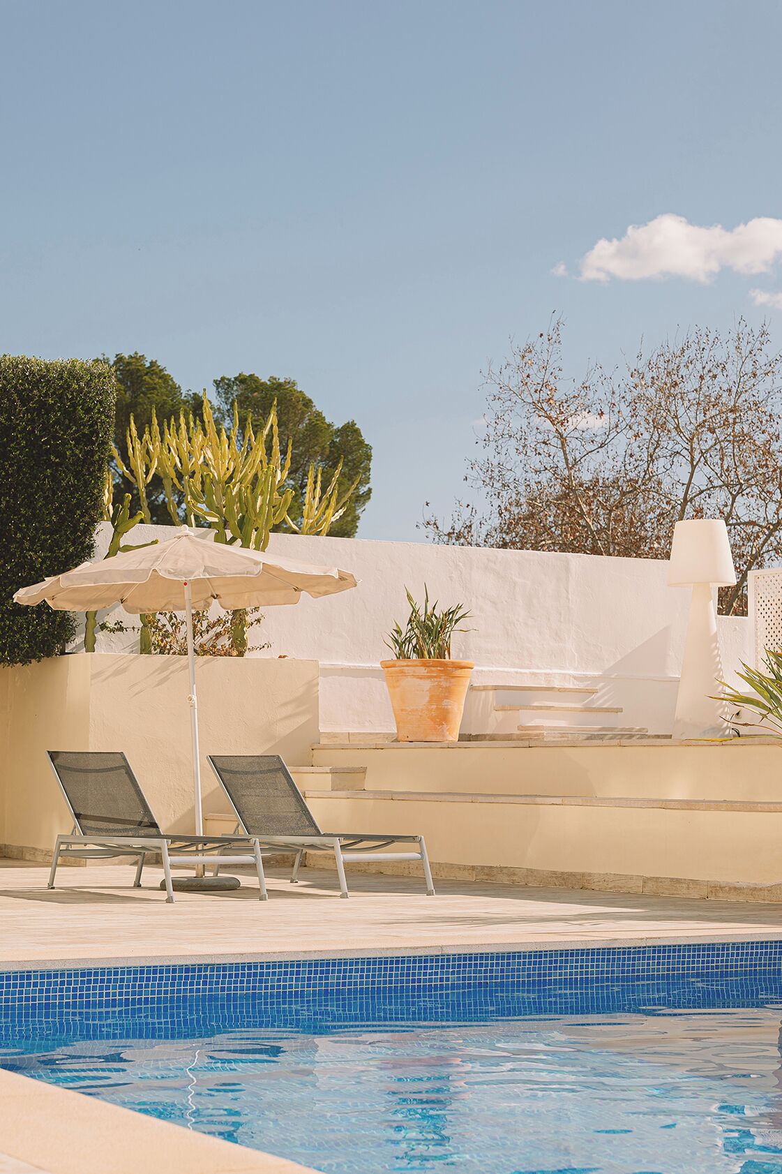 Una piscina al aire libre, tumbonas