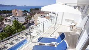 A balcony with two blue lounge chairs, a small table, and a white umbrella. - Aparthotel Novo Mar (Calvia)