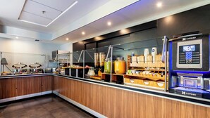 Una cocina moderna con armarios de madera, una cafetera y diversos electrodomésticos.