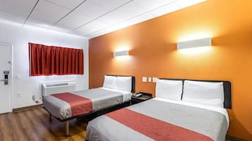 A hotel room with two beds, a red curtain, an air conditioning unit, and a wall-mounted light fixture.