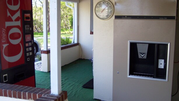 A room with a Coca-Cola vending machine, a clock, and a thermostat. - Shore Hills Motel (Manasquan)