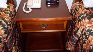 A wooden bedside table with a telephone and a radio. - Shore Hills Motel (Manasquan)