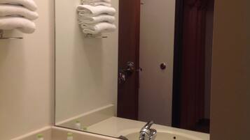A bathroom with a sink, mirror, and towel rack.