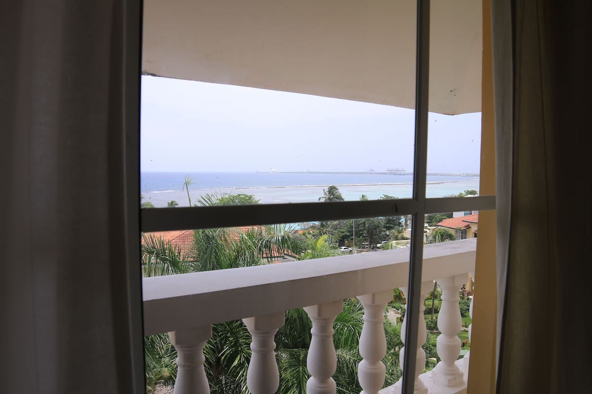 Ein Balkon mit Blick auf das Meer und Gebäude.