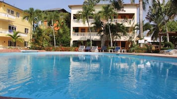 Una piscina al aire libre, sillones reclinables de piscina