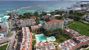 Ein Resort mit mehreren Gebäuden, einem Schwimmbad und Blick auf den Ozean.