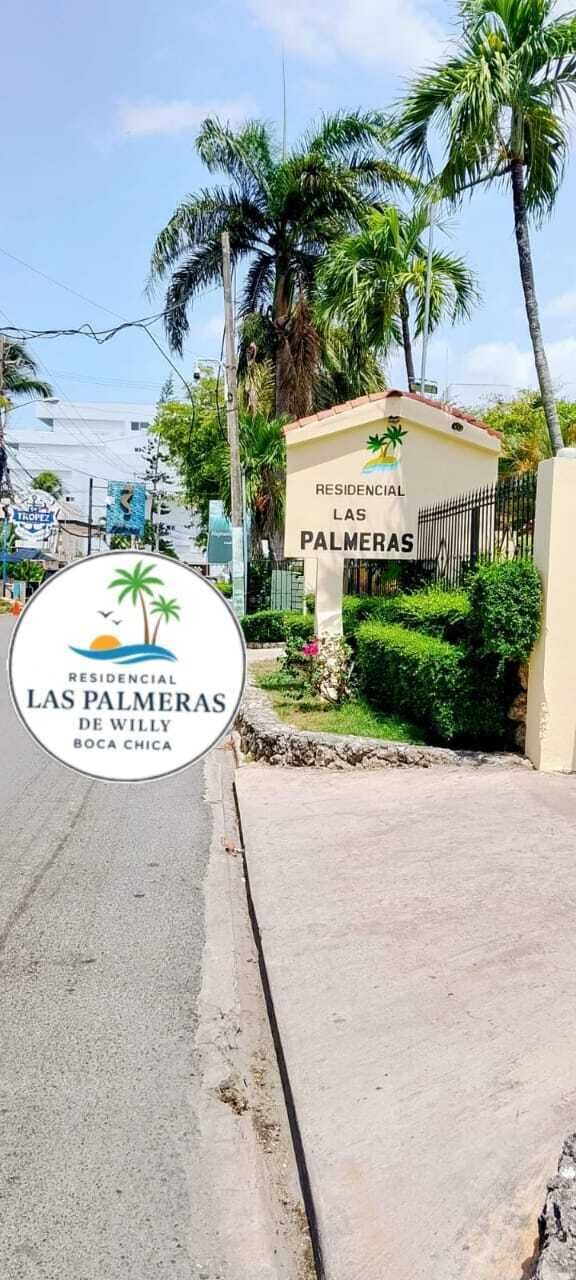 A residential property named 'Las Palmeras' with a sign indicating it's a 'Residencial de Willy Boca Chica.'
