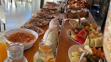 En morgenmadsbuffet med et udvalg af mad og drikke.